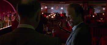 Movie still from “Glengarry Glen Ross” (1992), directed by James Foley – Two men in suits are talking in a restaurant; Medium shot, Over the shoulder angle