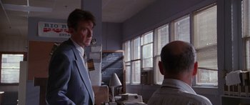 Movie still from “Glengarry Glen Ross” (1992), directed by James Foley – A man standing in front of another man in front of a chalkboard; Medium shot, Over the shoulder angle