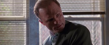 Movie still from “Glengarry Glen Ross” (1992), directed by James Foley – A man in a suit and tie looking down; Close Up shot, Low angle