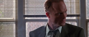 Movie still from “Glengarry Glen Ross” (1992), directed by James Foley – A person wearing a suit and tie; Close Up shot, Low angle