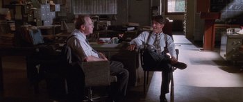 Movie still from “Glengarry Glen Ross” (1992), directed by James Foley – Two men sitting at a desk talking to each other; Medium shot, Over the shoulder angle
