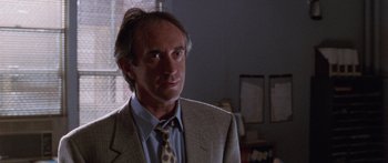 Movie still from “Glengarry Glen Ross” (1992), directed by James Foley – A person wearing a suit and a tie; Close Up shot, Over the shoulder angle