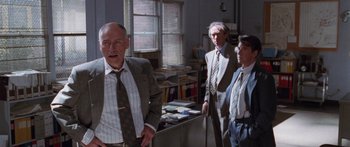 Movie still from “Glengarry Glen Ross” (1992), directed by James Foley – A group of men standing next to each other in a room; Medium shot, Low angle