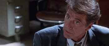 Movie still from “Glengarry Glen Ross” (1992), directed by James Foley – A person wearing a suit and tie; Close Up shot, Over the shoulder angle