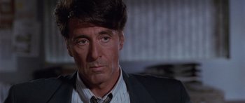 Movie still from “Glengarry Glen Ross” (1992), directed by James Foley – A person wearing a suit and tie; Close Up shot, Over the shoulder angle
