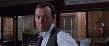 Movie still from “Glengarry Glen Ross” (1992), directed by James Foley – A person wearing a suit and tie; Close Up shot, Over the shoulder angle