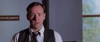Movie still from “Glengarry Glen Ross” (1992), directed by James Foley – A person wearing a suit and tie; Close Up shot, Low angle