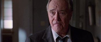 Movie still from “Glengarry Glen Ross” (1992), directed by James Foley – An older man wearing a suit and tie; Close Up shot, Over the shoulder angle