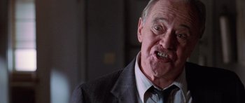 Movie still from “Glengarry Glen Ross” (1992), directed by James Foley – An older man in a suit and tie with his mouth wide open; Close Up shot, Low angle