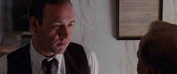 Movie still from “Glengarry Glen Ross” (1992), directed by James Foley – A person wearing a suit and tie; Close Up shot, Over the shoulder angle