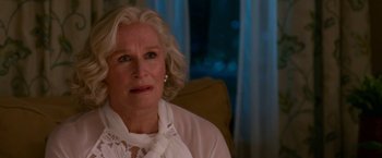 Movie still from “Father Figures” (2017), directed by Lawrence Sher – An older woman sitting in a chair looking at the camera; Close Up shot, Over the shoulder angle