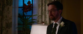 Movie still from “Father Figures” (2017), directed by Lawrence Sher – A person wearing a suit and tie; Close Up shot, Over the shoulder angle