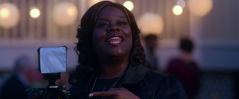 Movie still from “Father Figures” (2017), directed by Lawrence Sher – A person smiling with her hand up to her chest; Close Up shot, Over the shoulder angle