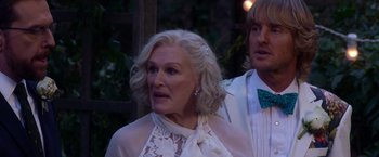 Movie still from “Father Figures” (2017), directed by Lawrence Sher – An older woman wearing a white dress and a man wearing a green bow tie; Close Up shot, Over the shoulder angle