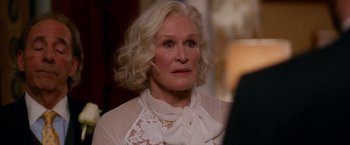 Movie still from “Father Figures” (2017), directed by Lawrence Sher – An older woman with blonde hair wearing a white blouse; Close Up shot, Over the shoulder angle