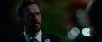 Movie still from “Father Figures” (2017), directed by Lawrence Sher – A person wearing a suit and tie; Close Up shot, Over the shoulder angle