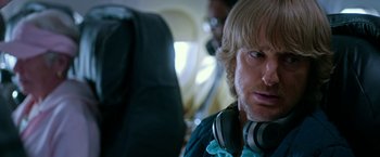Movie still from “Father Figures” (2017), directed by Lawrence Sher – A person with headphones on; Close Up shot, Over the shoulder angle