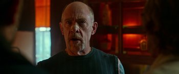 Movie still from “Father Figures” (2017), directed by Lawrence Sher – An older man with a shaved head and a beard; Close Up shot, Low angle