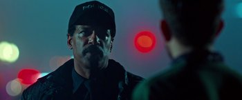 Movie still from “Father Figures” (2017), directed by Lawrence Sher – A man in a police uniform talking to another man; Close Up shot, Over the shoulder angle