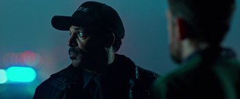Movie still from “Father Figures” (2017), directed by Lawrence Sher – A man wearing a police uniform and a hat; Close Up shot, Over the shoulder angle