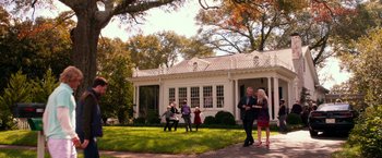 Movie still from “Father Figures” (2017), directed by Lawrence Sher – A group of people standing in front of a white house; Extreme Wide shot, High angle