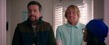 Movie still from “Father Figures” (2017), directed by Lawrence Sher – Two men standing next to each other in front of a window; Medium shot, Over the shoulder angle