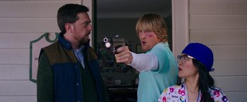 Movie still from “Father Figures” (2017), directed by Lawrence Sher – A man pointing a gun at another man in front of him; Medium shot, Over the shoulder angle