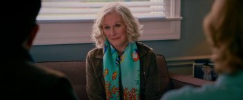 Movie still from “Father Figures” (2017), directed by Lawrence Sher – A woman sitting on a couch wearing a scarf; Close Up shot, Over the shoulder angle