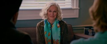 Movie still from “Father Figures” (2017), directed by Lawrence Sher – A woman with white curly hair wearing a blue scarf; Medium shot, Over the shoulder angle