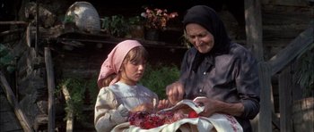 Movie still from “Fiddler on the Roof” (1971), directed by Norman Jewison – An older woman and a young girl sitting next to each other; Medium shot, High angle