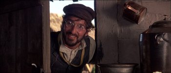 Movie still from “Fiddler on the Roof” (1971), directed by Norman Jewison – A man with a hat and glasses is looking at the camera; Close Up shot, Low angle