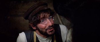 Movie still from “Fiddler on the Roof” (1971), directed by Norman Jewison – A man wearing glasses and a hat and looking surprised; Close Up shot, Over the shoulder angle
