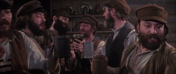 Movie still from “Fiddler on the Roof” (1971), directed by Norman Jewison – A group of men standing next to each other holding cups; Medium shot, High angle
