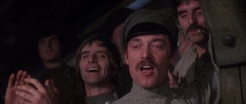 Movie still from “Fiddler on the Roof” (1971), directed by Norman Jewison – A man with a mustache and a hat is smiling for the camera; Close Up shot, Low angle
