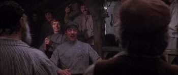 Movie still from “Fiddler on the Roof” (1971), directed by Norman Jewison – A group of men standing next to each other in a room; Medium shot, Low angle