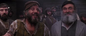 Movie still from “Fiddler on the Roof” (1971), directed by Norman Jewison – A group of men standing next to each other in a room; Close Up shot, Low angle