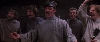 Movie still from “Fiddler on the Roof” (1971), directed by Norman Jewison – A group of men standing next to each other in a room; Medium shot, Low angle