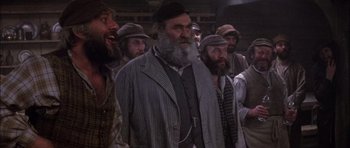 Movie still from “Fiddler on the Roof” (1971), directed by Norman Jewison – A group of men standing next to each other; Medium shot, Low angle
