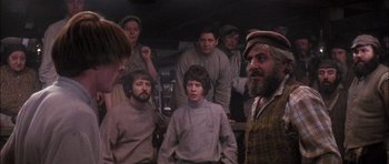 Movie still from “Fiddler on the Roof” (1971), directed by Norman Jewison – A group of people standing in a room; Medium shot, Over the shoulder angle