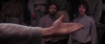 Movie still from “Fiddler on the Roof” (1971), directed by Norman Jewison – A man with his hand outstreched in front of a crowd; Close Up shot, Over the shoulder angle