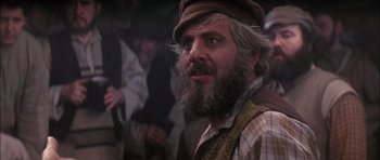 Movie still from “Fiddler on the Roof” (1971), directed by Norman Jewison – A man with a beard and a hat on; Close Up shot, Over the shoulder angle