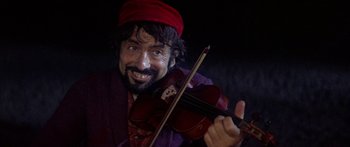 Movie still from “Fiddler on the Roof” (1971), directed by Norman Jewison – A man with a beard and mustache holding a violin; Close Up shot, Low angle