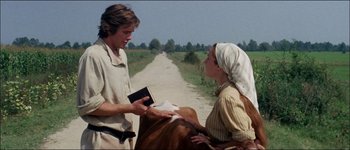 Movie still from “Fiddler on the Roof” (1971), directed by Norman Jewison – A man and a woman holding a bible near a cow; Medium shot, Over the shoulder angle