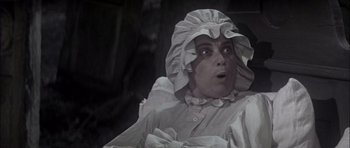 Movie still from “Fiddler on the Roof” (1971), directed by Norman Jewison – A man in a white robe and a white hat; Close Up shot, High angle