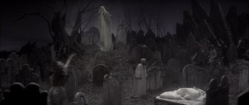 Movie still from “Fiddler on the Roof” (1971), directed by Norman Jewison – An image of a graveyard scene with a person in the background; Wide shot, High angle