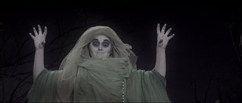 Movie still from “Fiddler on the Roof” (1971), directed by Norman Jewison – A woman dressed as a ghost making a funny face; Medium shot, Low angle