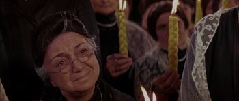 Movie still from “Fiddler on the Roof” (1971), directed by Norman Jewison – A group of people holding lit candles in front of a crowd; Close Up shot, Over the shoulder angle