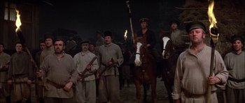 Movie still from “Fiddler on the Roof” (1971), directed by Norman Jewison – A group of men standing around on horses; Wide shot, High angle