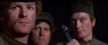 Movie still from “Fiddler on the Roof” (1971), directed by Norman Jewison – A group of men standing next to each other in a dark room; Close Up shot, Low angle