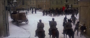 Movie still from “Fiddler on the Roof” (1971), directed by Norman Jewison – A group of men riding horses in the middle of a street; Extreme Wide shot, High angle